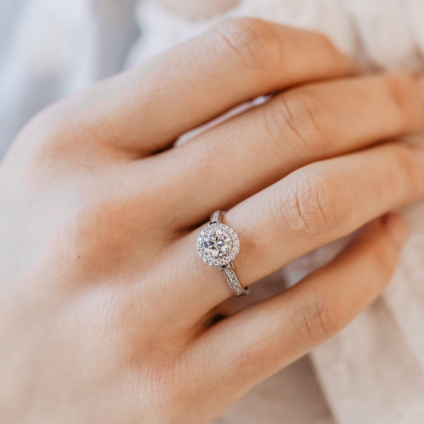 Ethica Diamonds Halo Ring featuring a round brilliant centre diamond, and diamonds running down the shoulders.